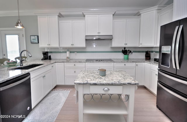 kitchen with crown molding, a sink, black appliances, under cabinet range hood, and white cabinetry