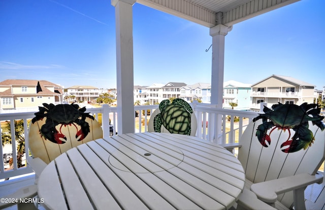 wooden deck with a residential view and outdoor dining area