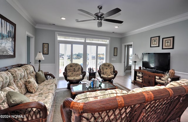 living area with visible vents, ornamental molding, ceiling fan, and wood finished floors