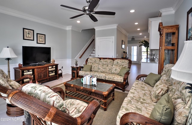 living room with a ceiling fan, crown molding, wainscoting, stairway, and recessed lighting