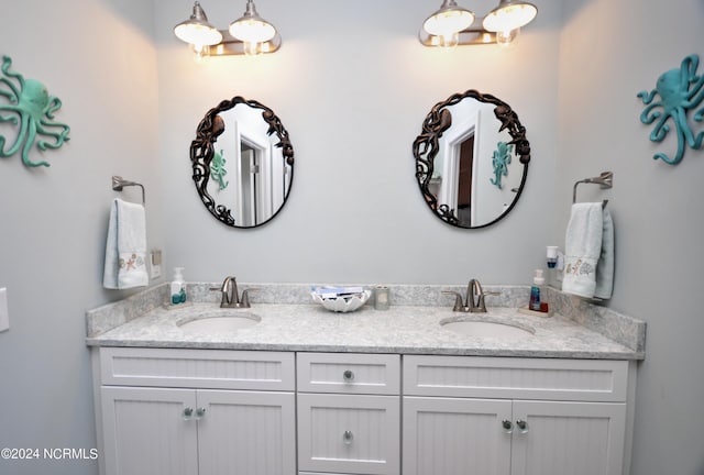full bathroom with double vanity and a sink