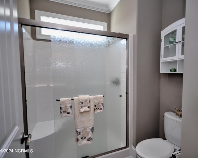 full bathroom featuring crown molding, toilet, and a stall shower
