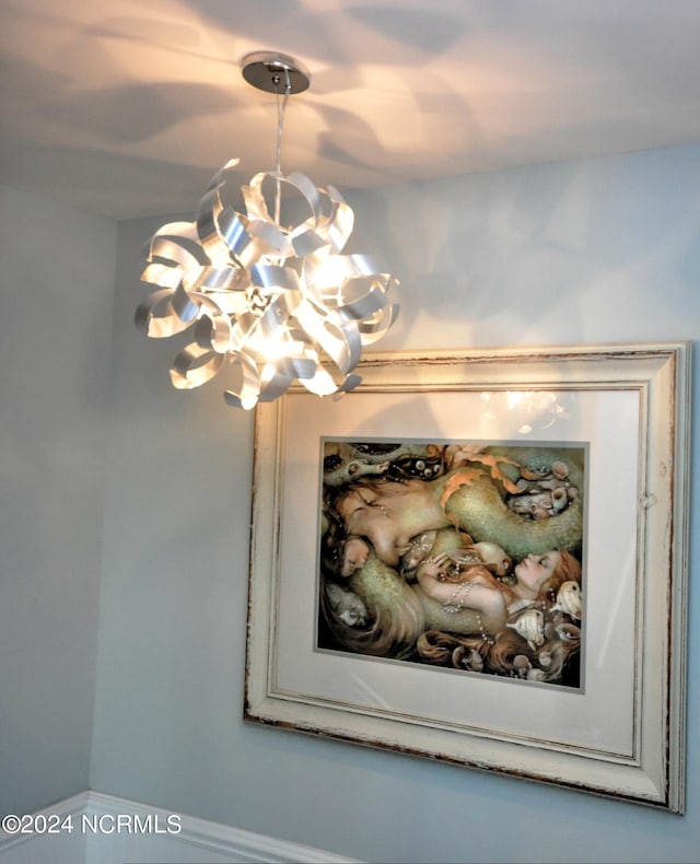 interior details featuring baseboards and a notable chandelier