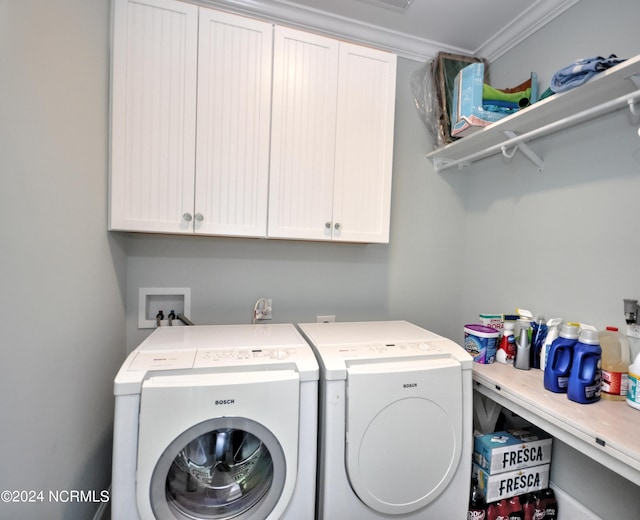washroom featuring washer and dryer, ornamental molding, and cabinet space