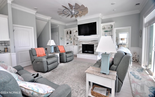 living room with light wood-style floors, ornamental molding, a fireplace, and visible vents