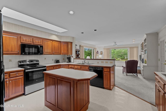 kitchen with black appliances, a sink, light countertops, a peninsula, and brown cabinetry