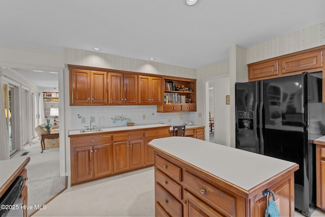 kitchen featuring black fridge, wallpapered walls, open shelves, a sink, and light countertops