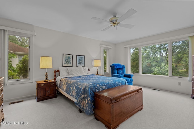 bedroom with light carpet, multiple windows, and baseboards