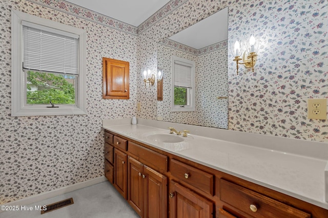 bathroom with a chandelier, wallpapered walls, vanity, and baseboards