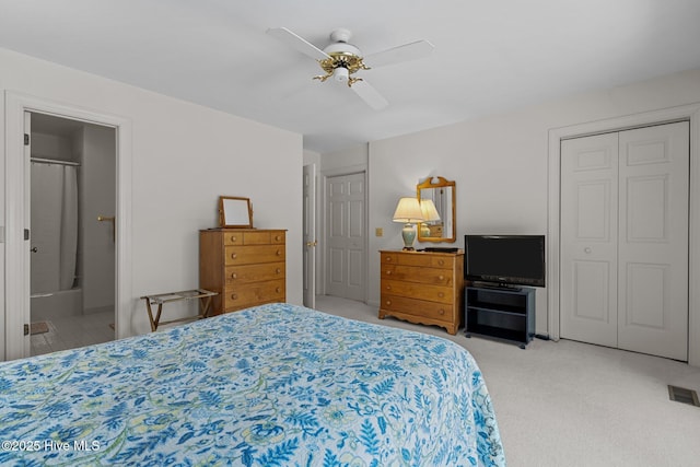 carpeted bedroom featuring ensuite bath and a ceiling fan