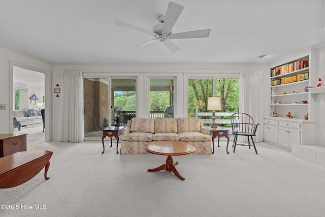 living room with light carpet, plenty of natural light, and a ceiling fan
