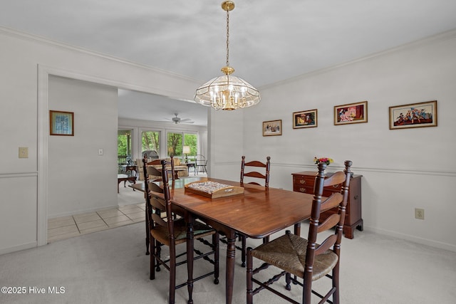 dining room with ornamental molding, a chandelier, light carpet, baseboards, and a ceiling fan