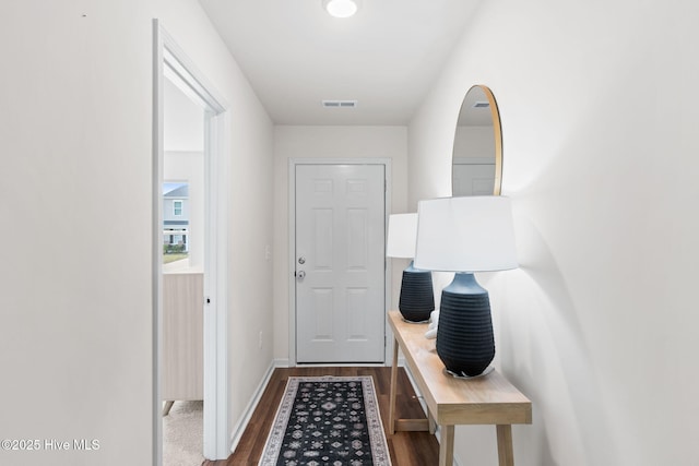 doorway to outside with baseboards, dark wood finished floors, and visible vents