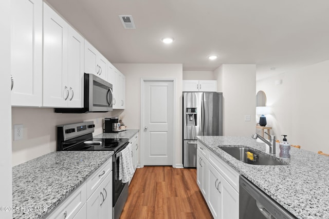 kitchen featuring visible vents, a sink, white cabinets, and stainless steel appliances
