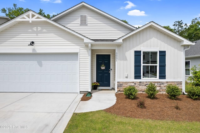 view of front of property featuring a garage, board and batten siding, concrete driveway, and stone siding