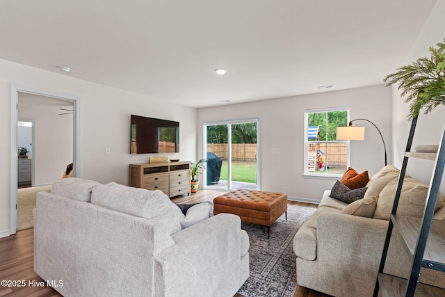 living room featuring baseboards, wood finished floors, and visible vents