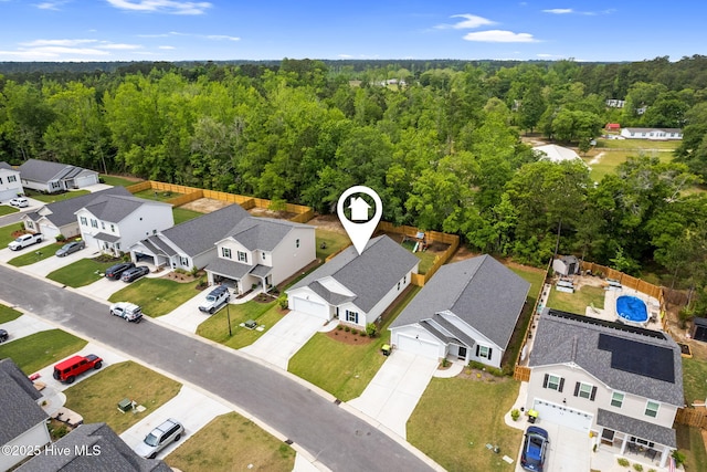 drone / aerial view featuring a view of trees and a residential view