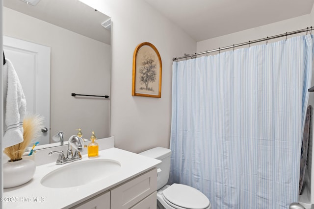 bathroom featuring vanity, curtained shower, and toilet