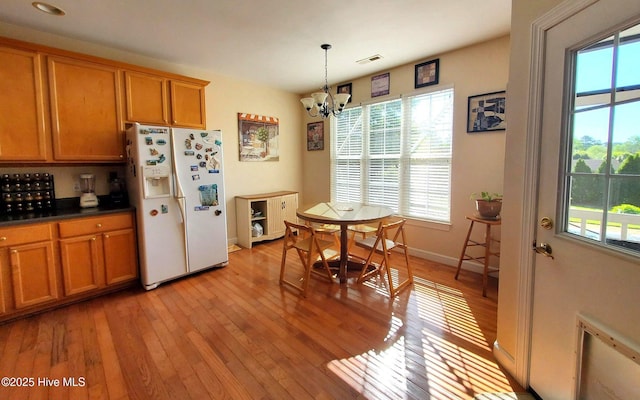 interior space with an inviting chandelier, visible vents, light wood finished floors, and a healthy amount of sunlight