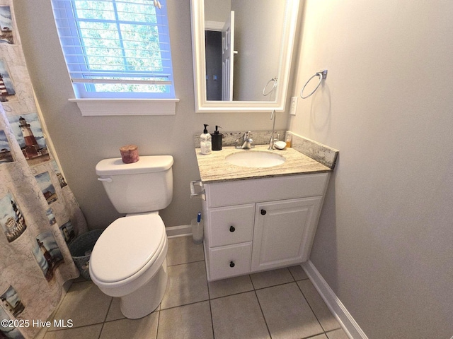 bathroom featuring tile patterned flooring, baseboards, toilet, and vanity