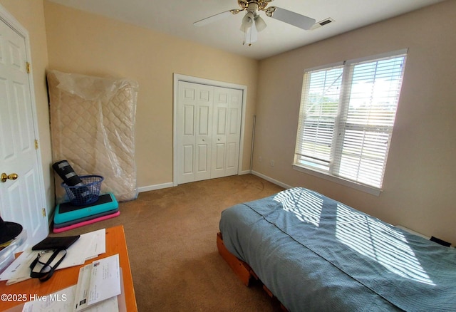 bedroom featuring a ceiling fan, visible vents, baseboards, a closet, and carpet
