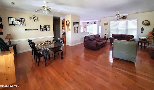 dining area with a ceiling fan, baseboards, visible vents, and wood finished floors