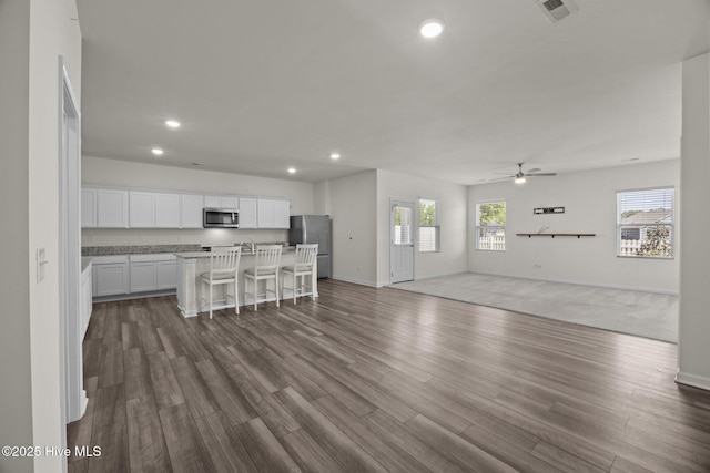 living area featuring ceiling fan, dark wood finished floors, recessed lighting, baseboards, and visible vents