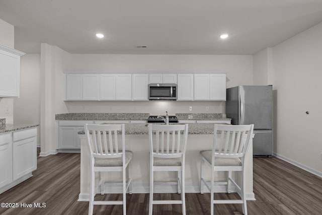 kitchen with white cabinets, stainless steel appliances, and dark wood finished floors
