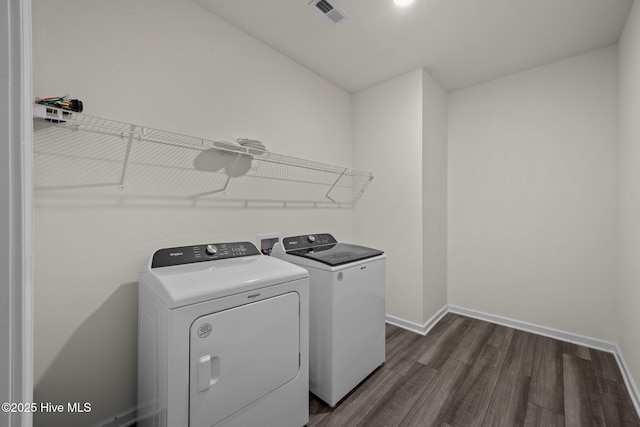 clothes washing area featuring laundry area, dark wood-style flooring, visible vents, baseboards, and separate washer and dryer