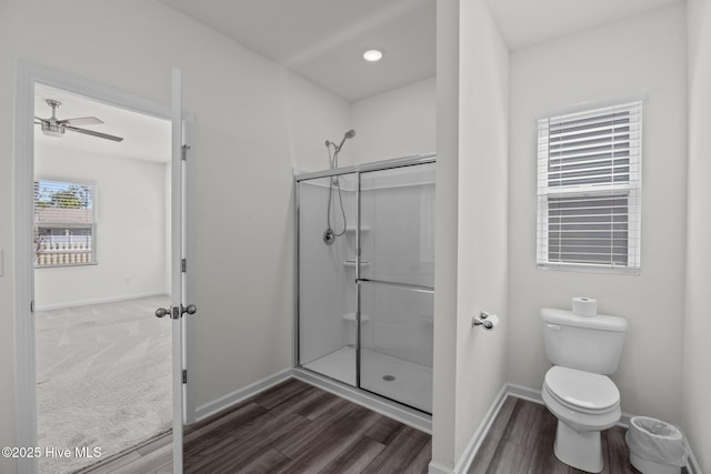 full bathroom with baseboards, a stall shower, toilet, and wood finished floors