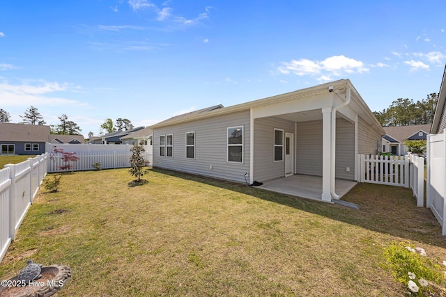 rear view of house featuring a fenced backyard, a patio, and a yard