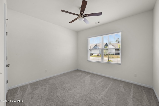 empty room with baseboards, a ceiling fan, carpet, and visible vents