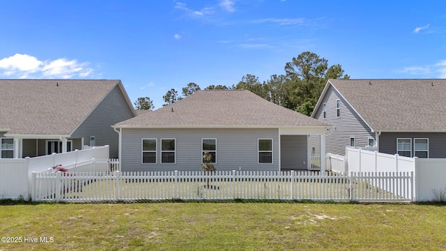 back of house with a fenced backyard and a yard