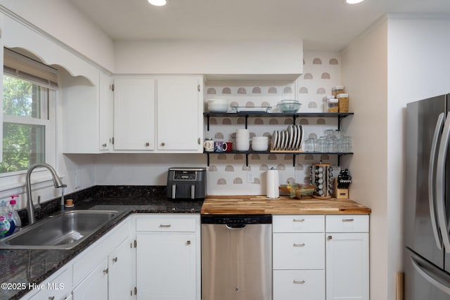 kitchen featuring stainless steel appliances, recessed lighting, white cabinetry, and a sink