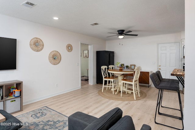 dining area featuring baseboards, ceiling fan, light wood-style flooring, and visible vents