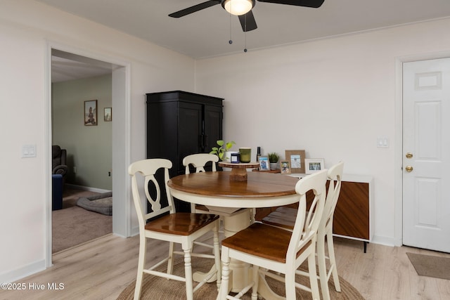 dining room with a ceiling fan, baseboards, and light wood-style floors