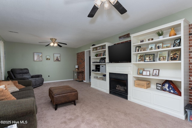 living area featuring carpet floors, ceiling fan, visible vents, and a fireplace