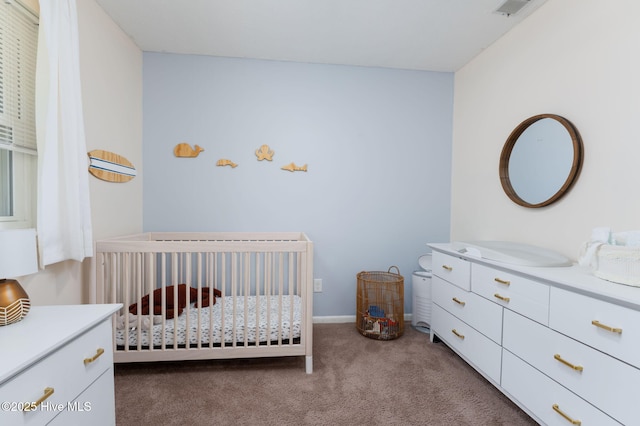 bedroom with carpet floors, a nursery area, baseboards, and visible vents