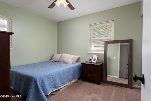 bedroom with a ceiling fan, baseboards, and light carpet
