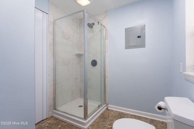 bathroom with baseboards, electric panel, a stall shower, and toilet