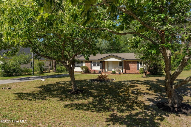 single story home featuring covered porch, brick siding, and a front lawn