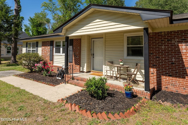 view of front facade with brick siding and covered porch