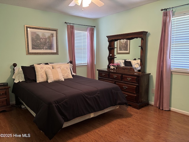 bedroom with baseboards, ceiling fan, and wood finished floors