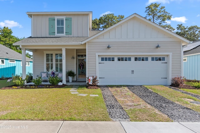 view of front of house with a front lawn, a garage, board and batten siding, covered porch, and driveway