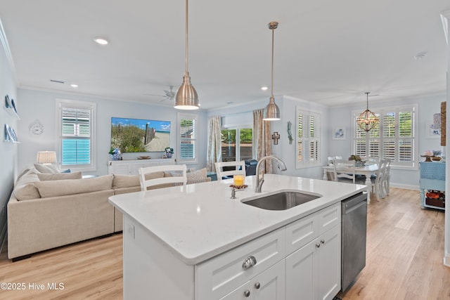 kitchen featuring a sink, light wood-style floors, stainless steel dishwasher, and open floor plan