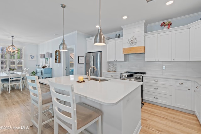 kitchen featuring a sink, light countertops, stainless steel appliances, backsplash, and ornamental molding