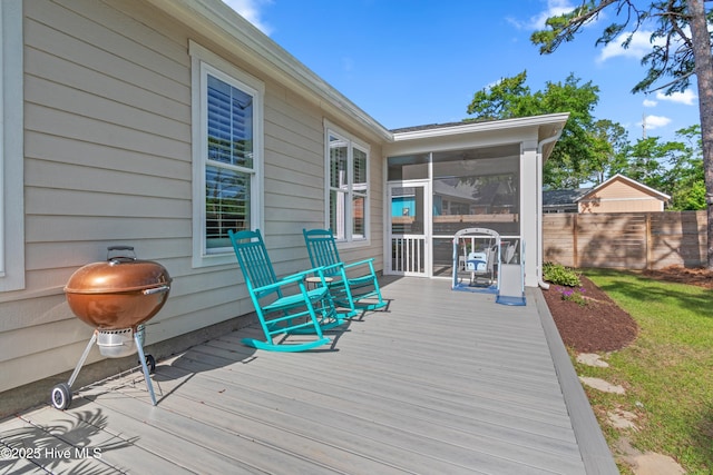 deck featuring fence and a sunroom