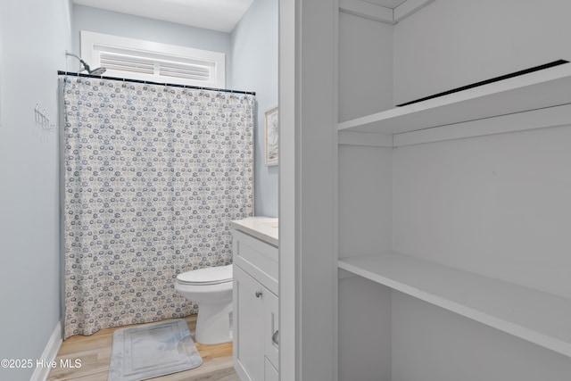 full bathroom featuring toilet, curtained shower, wood finished floors, and vanity