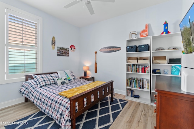 bedroom with a ceiling fan, baseboards, and wood finished floors