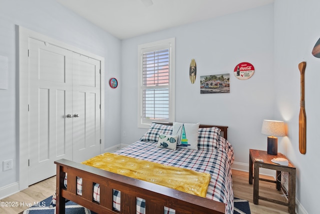 bedroom featuring a closet, baseboards, and light wood-type flooring